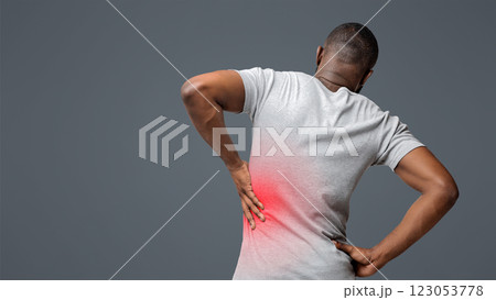 Kidney stones. Afro man holding his hand behind his back, pain in kidney, inflamed zone highlighted in red, back view Kidney stones. Afro man holding his hand behind his back, pain in kidney, inflamed zone highlighted in red, back view 123053778