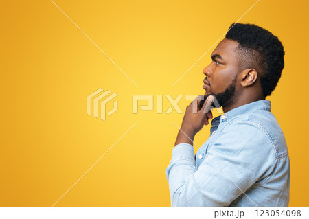 Searching for solution. Thoughtful black man profile portrait on yellow studio background, copy space Searching for solution. Thoughtful black man profile portrait on yellow studio background, copy space 123054098