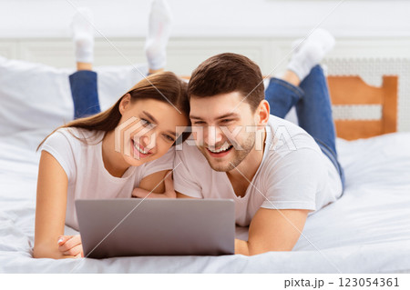 Young Spouses Using Laptop Watching Movie Lying In Bed Indoor. Weekend Leisure. Selective Focus 123054361