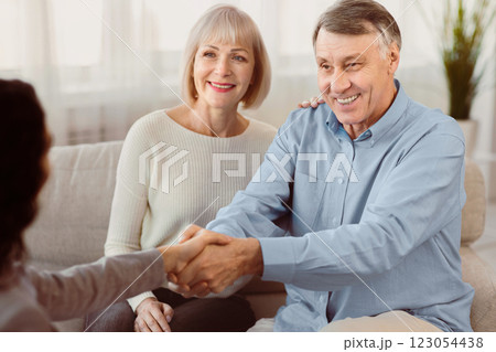 Nice To Meet You. Young female therapist meeting elderly couple for a counselling session, greeting with handshake Nice To Meet You. Young female therapist meeting elderly couple for a counselling session, greeting with handshake 123054438