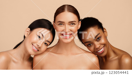 Three Joyful Girls Posing Wrapped In White Towels Standing On Gray Studio Background After Shower. Spa And Body Care Concept 123054441