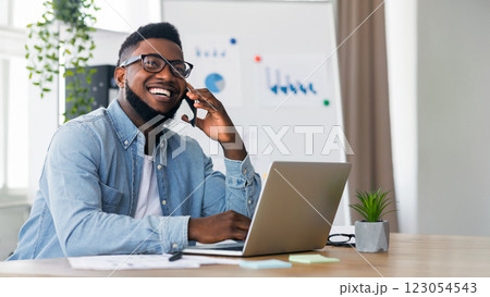 Great news. Happy african american businessman received good news on phone, his project received financing 123054543