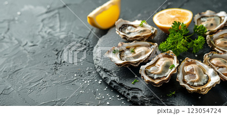 Enjoy a platter of fresh oysters adorned with lemon wedges and parsley, highlighting a delicious seafood experience. 123054724