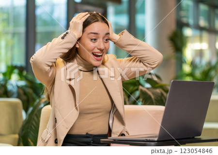 Happy business woman using laptop celebrating success victory, winning, play online game, good news 123054846