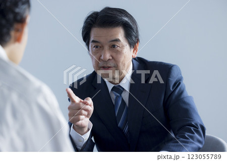 真剣な表情でプレゼンをするミドルビジネスマン 123055789