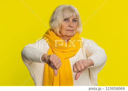 Upset grandmother woman shows thumbs down gesture disapproval dissatisfied dislike negative feedback 123056069