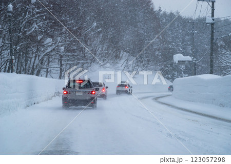 降り積もる雪の国道のドライブと前を走る車　b-1 123057298
