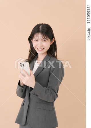スマホを持つスーツの女性 スマホを持つスーツの女性 123059384