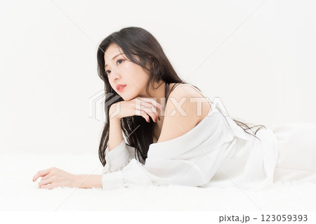 ビューティーイメージ 白シャツを着て頬付を付いて寝そべる若い女性 アンニュイ ビューティーイメージ 白シャツを着て頬付を付いて寝そべる若い女性 アンニュイ 123059393