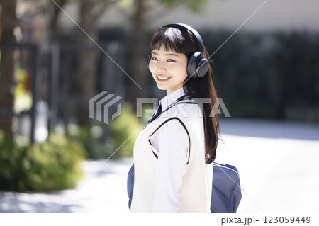 ヘッドフォンをしてスマホを持っている女子高生 123059449