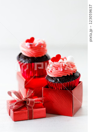 Chocolate cupcakes with pink cream and heart shaped sprinkles. Chocolate cupcakes with pink cream and heart shaped sprinkles. 123059637