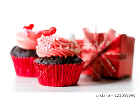 Chocolate cupcakes with pink cream and heart shaped sprinkles. 123059649