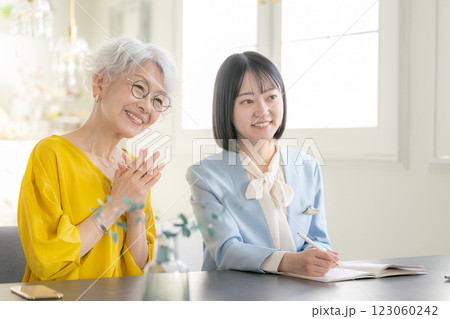 打ち合わせするスーツ姿の女性と高齢者女性 打ち合わせするスーツ姿の女性と高齢者女性 123060242