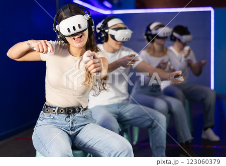Girl in vr glasses with joysticks playing a video game 123060379