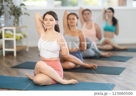 Group of women of working out practice Lord of fishes pose 123060500