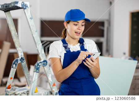 Woman builder talking on the phone - making an order for building materials on phone 123060586
