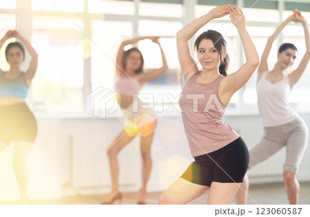 During lesson, girl learn to move and perform dance in heels with women companions 123060587