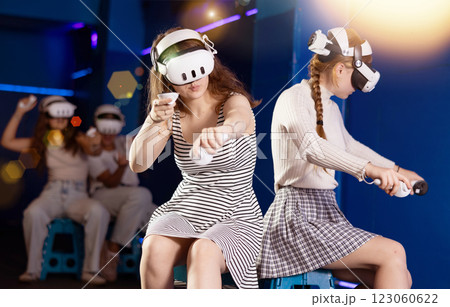 Two girls competing in team-based virtual reality game 123060622