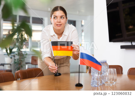 Preparing for business presentation - secretary places flags of Germany and Russia on negotiating table Preparing for business presentation - secretary places flags of Germany and Russia on negotiating table 123060832