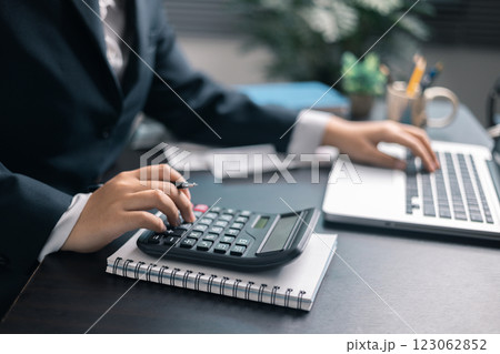 Finance bank tax expense accounting budget money businessman hand use calculator Financial calculate accountant close up calculator with graph chart write office desk Business expense analysis saving 123062852