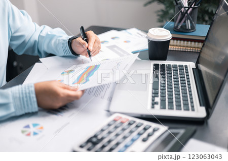 Finance bank tax expense accounting budget money businessman hand use calculator Financial calculate accountant close up calculator with graph chart write office desk Business expense analysis saving 123063043