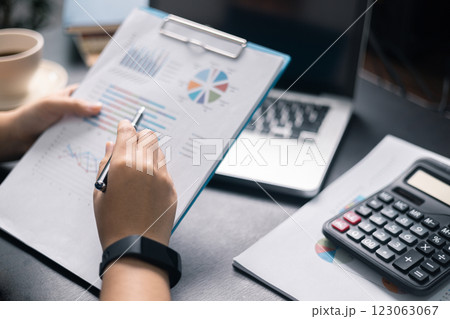 Finance bank tax expense accounting budget money businessman hand use calculator Financial calculate accountant close up calculator with graph chart write office desk Business expense analysis saving 123063067