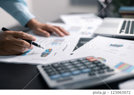 Finance bank tax expense accounting budget money businessman hand use calculator Financial calculate accountant close up calculator with graph chart write office desk Business expense analysis saving 123063072