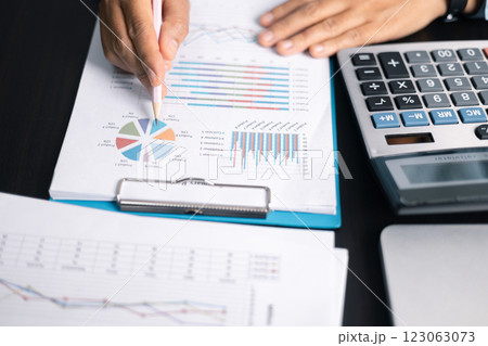 Finance bank tax expense accounting budget money businessman hand use calculator Financial calculate accountant close up calculator with graph chart write office desk Business expense analysis saving 123063073