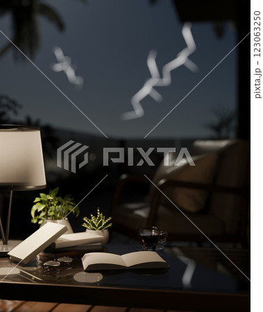 A close-up of a black coffee table with decorative items in a modern living room at night. 123063250