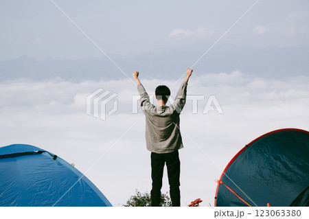 Man traveler with camera backpack hiking outdoor travel lifestyle and adventure concept. cap backpack and join of tourist for green mountain tour, beauty of nature and expansive sky people of tourism Man traveler with camera backpack hiking outdoor travel lifestyle and adventure concept. cap backpack and join of tourist for green mountain tour, beauty of nature and expansive sky people of tourism 123063380