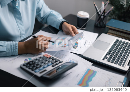 Finance bank tax expense accounting budget money businessman hand use calculator Financial calculate accountant close up calculator with graph chart write office desk Business expense analysis saving 123063440