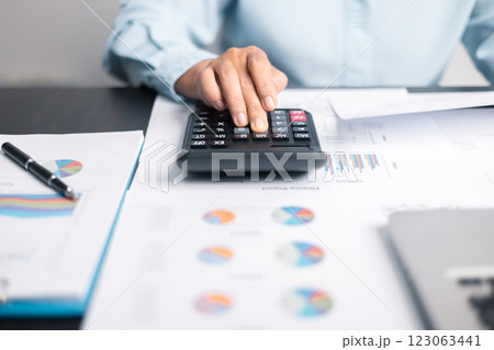 Finance bank tax expense accounting budget money businessman hand use calculator Financial calculate accountant close up calculator with graph chart write office desk Business expense analysis saving 123063441