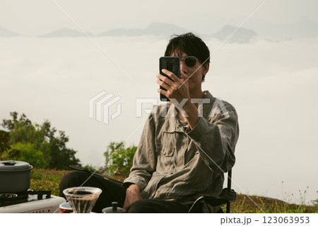 Young business man working computer on peak hill. Hiker online shopping on laptop at sunset, sunrise on top mountain, freelance person remote work with digital tablet. travel vacation holiday concept 123063953