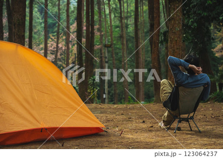 solo traveler in nature concept with asian man camping and see pink cherry blossom tree and pine tree with sunrise in springtime season solo traveler in nature concept with asian man camping and see pink cherry blossom tree and pine tree with sunrise in springtime season 123064237