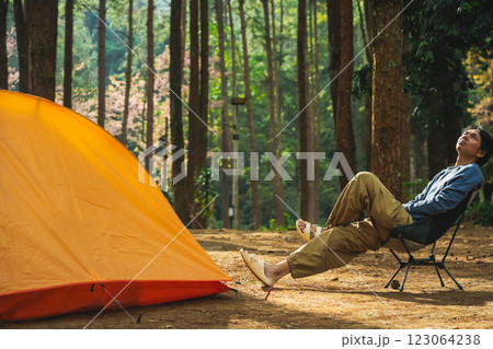 solo traveler in nature concept with asian man camping and see pink cherry blossom tree and pine tree with sunrise in springtime season solo traveler in nature concept with asian man camping and see pink cherry blossom tree and pine tree with sunrise in springtime season 123064238