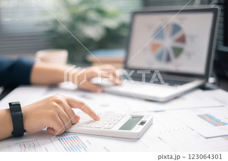 Finance bank tax expense accounting budget money businessman hand use calculator Financial calculate accountant close up calculator with graph chart write office desk Business expense analysis saving 123064301