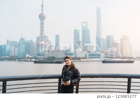 woman traveler visiting in Shanghai, China. Happy Female Tourist sightseeing Shanghai view of Lujiazui in The Bund of Shanghai. landmark and popular for tourism attractions. Vacation concept woman traveler visiting in Shanghai, China. Happy Female Tourist sightseeing Shanghai view of Lujiazui in The Bund of Shanghai. landmark and popular for tourism attractions. Vacation concept 123065277