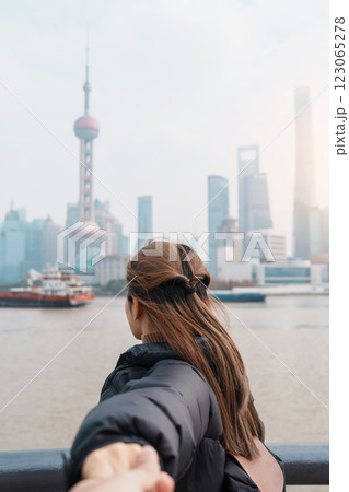 Couple traveler visiting in Shanghai, China. Tourists sightseeing Shanghai view of Lujiazui on The Bund of Shanghai. landmark and popular for tourism attractions. Vacation concept 123065278