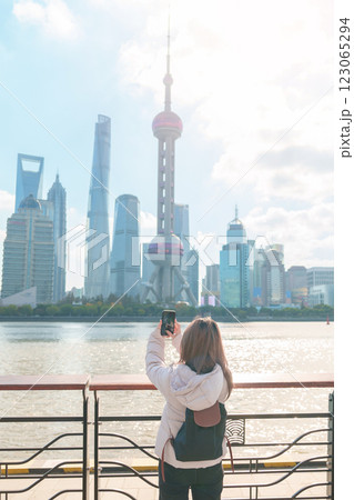 woman traveler visiting in Shanghai, China. Female Tourist with backpack sightseeing Shanghai view of Lujiazui in The north Bund of Shanghai. landmark and popular for tourism attractions 123065294