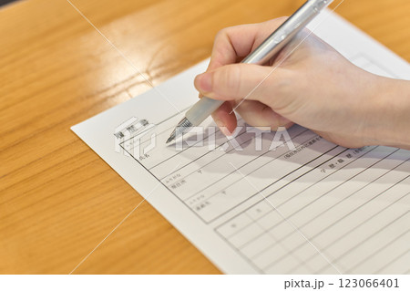 履歴書に記入する女性の手元 123066401