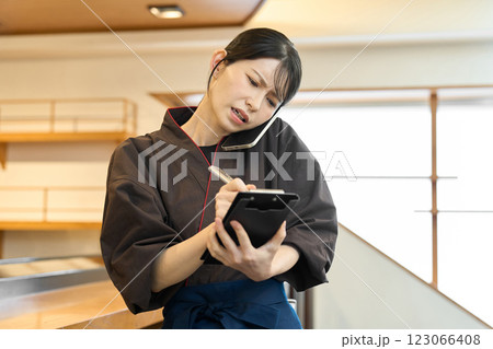 忙しそうに電話で予約を受ける従業員 123066408