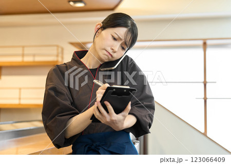 忙しそうに電話で予約を受ける従業員 123066409