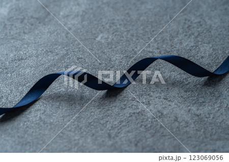 グレーの背景に紺のリボン 123069056