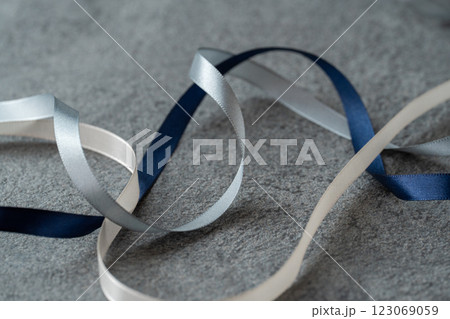グレーの背景に紺のリボン 123069059