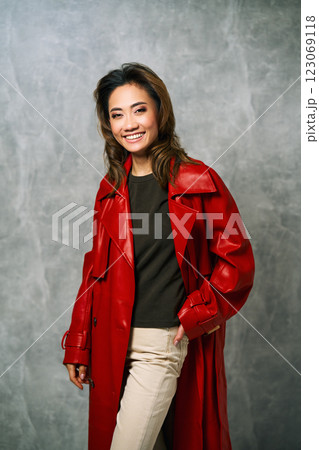 Stylish fashion woman in red coat and trendy casual outfit posing on grey background Stylish fashion woman in red coat and trendy casual outfit posing on grey background 123069118