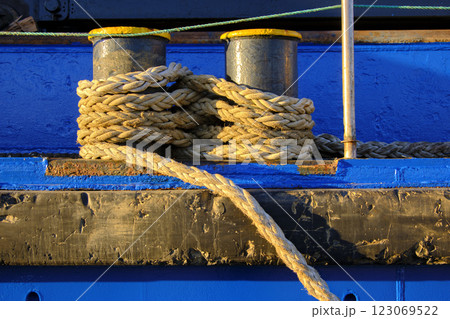 Nautical rope coiled on blue dock bollards 123069522