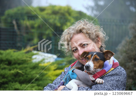 Smiling woman hugging jack russell dog in garden 123069667