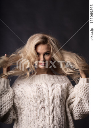 Studio photo portrait of a young pretty blonde on a dark background, close-up portrait of a woman 123069868
