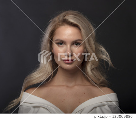 Studio photo portrait of a young pretty blonde on a dark background, close-up portrait of a woman 123069880