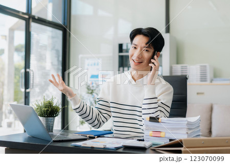 Portrait of a successful business man sitting at the desk, looking to camera. Portrait of a successful business man sitting at the desk, looking to camera. 123070099